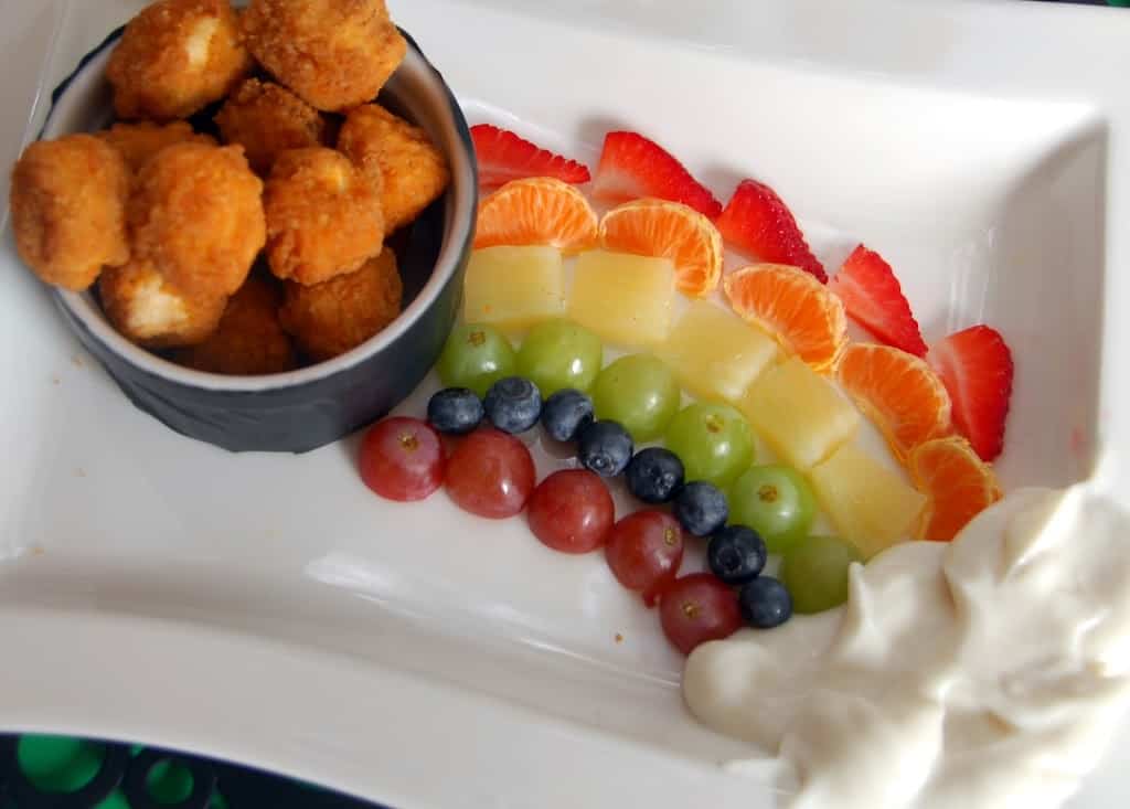 St. Patricks food like a bowl of chicken nuggets, with fruit rainbow and a yogurt dip cloud.